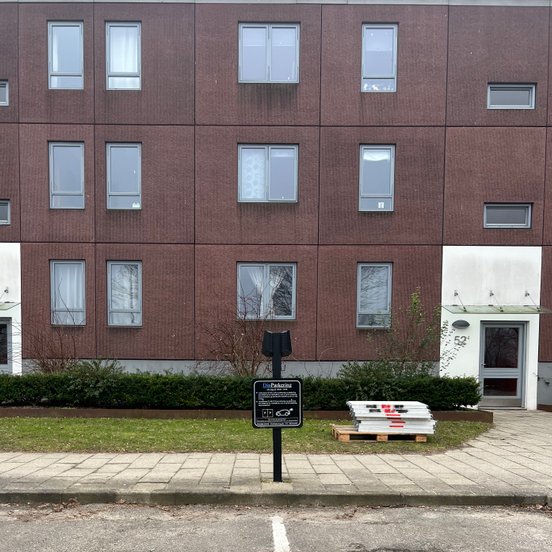 Easee ladestander i boligforening placeret foran parkeringsplads, side