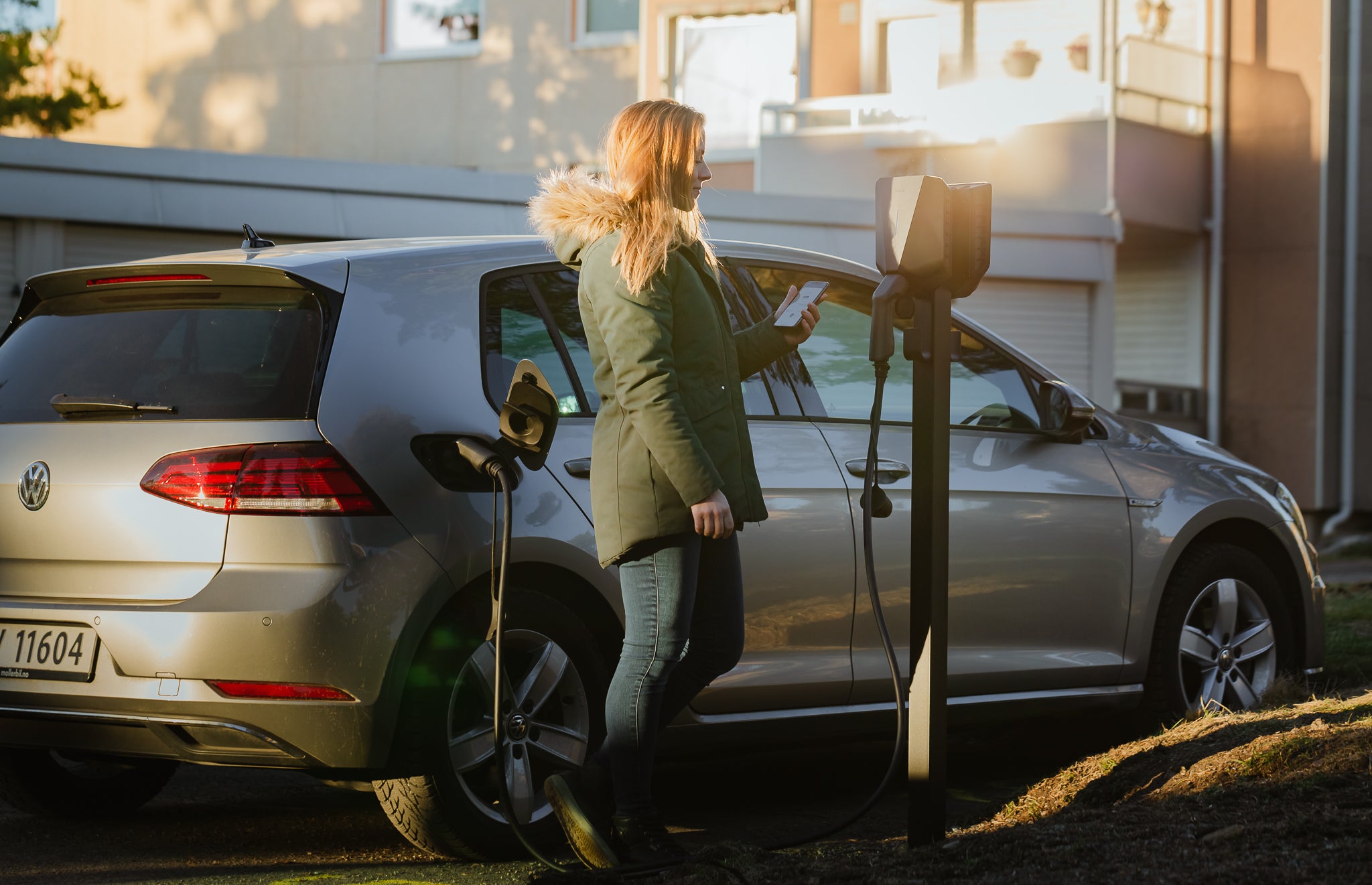 Kvinde oplader VW elbil i boligforening på Easee ladestander, front