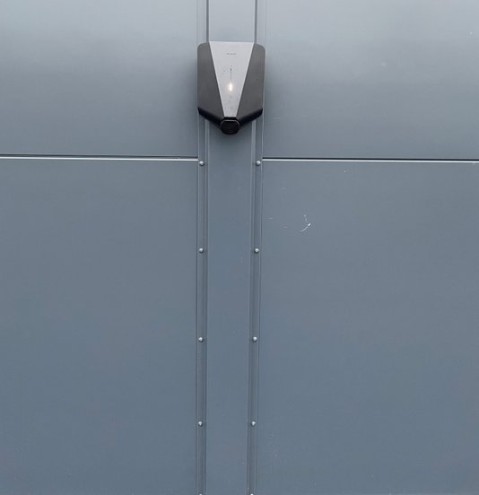 Grå Easee ladeboks placeret på grå væg hos Sportscenter, front